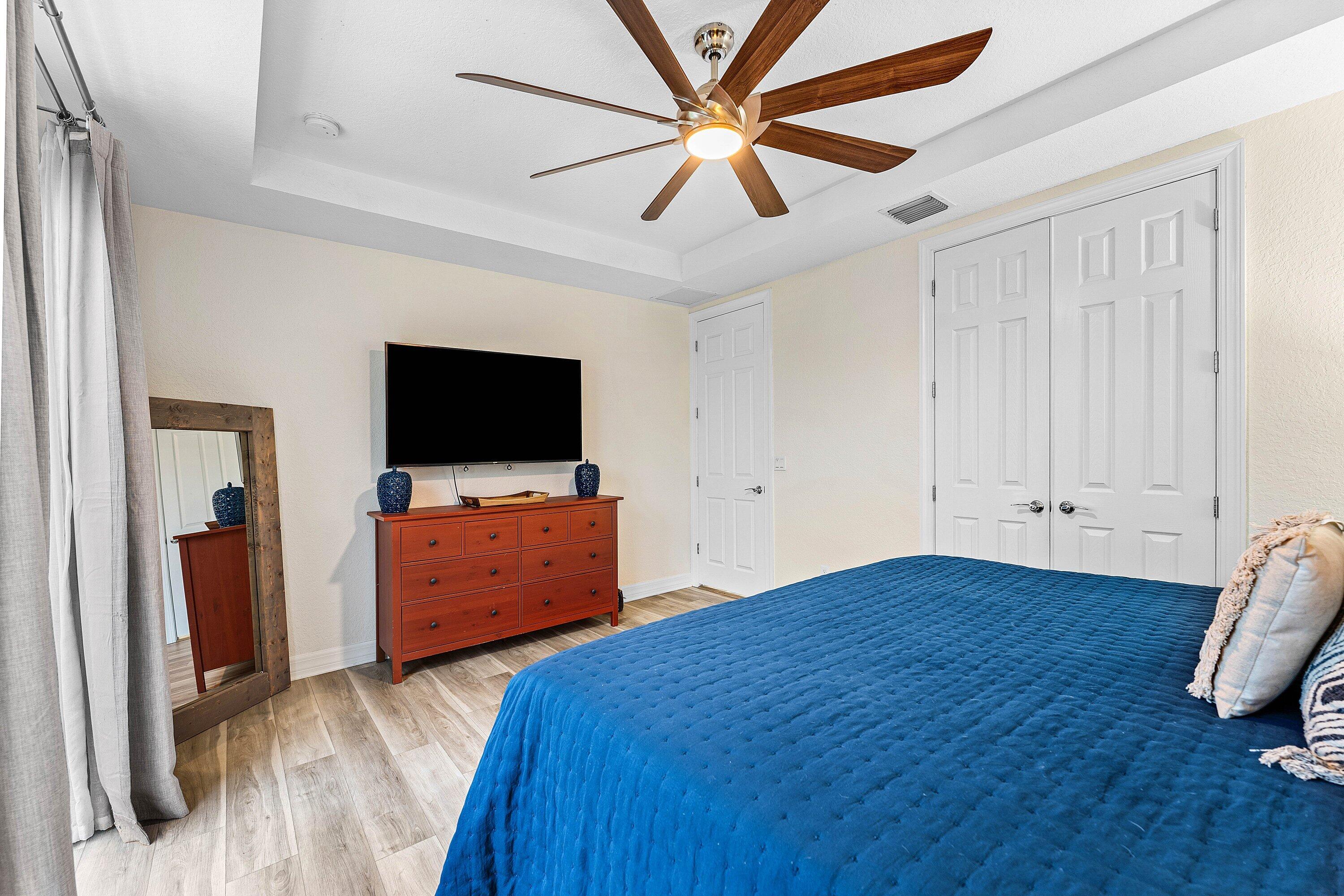 1056 Community Drive Jupiter, FL 33458 - Photo 22 of 50 a bedroom with furniture and flat screen tv