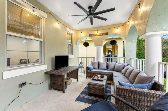 a living room with furniture a flat screen tv and a floor to ceiling window