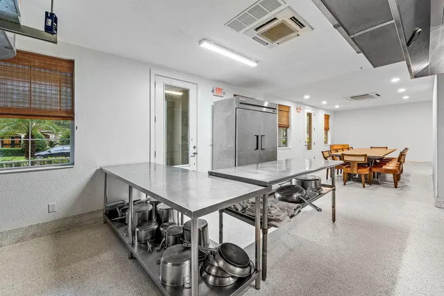 a living room with furniture a flat screen tv and a refrigerator