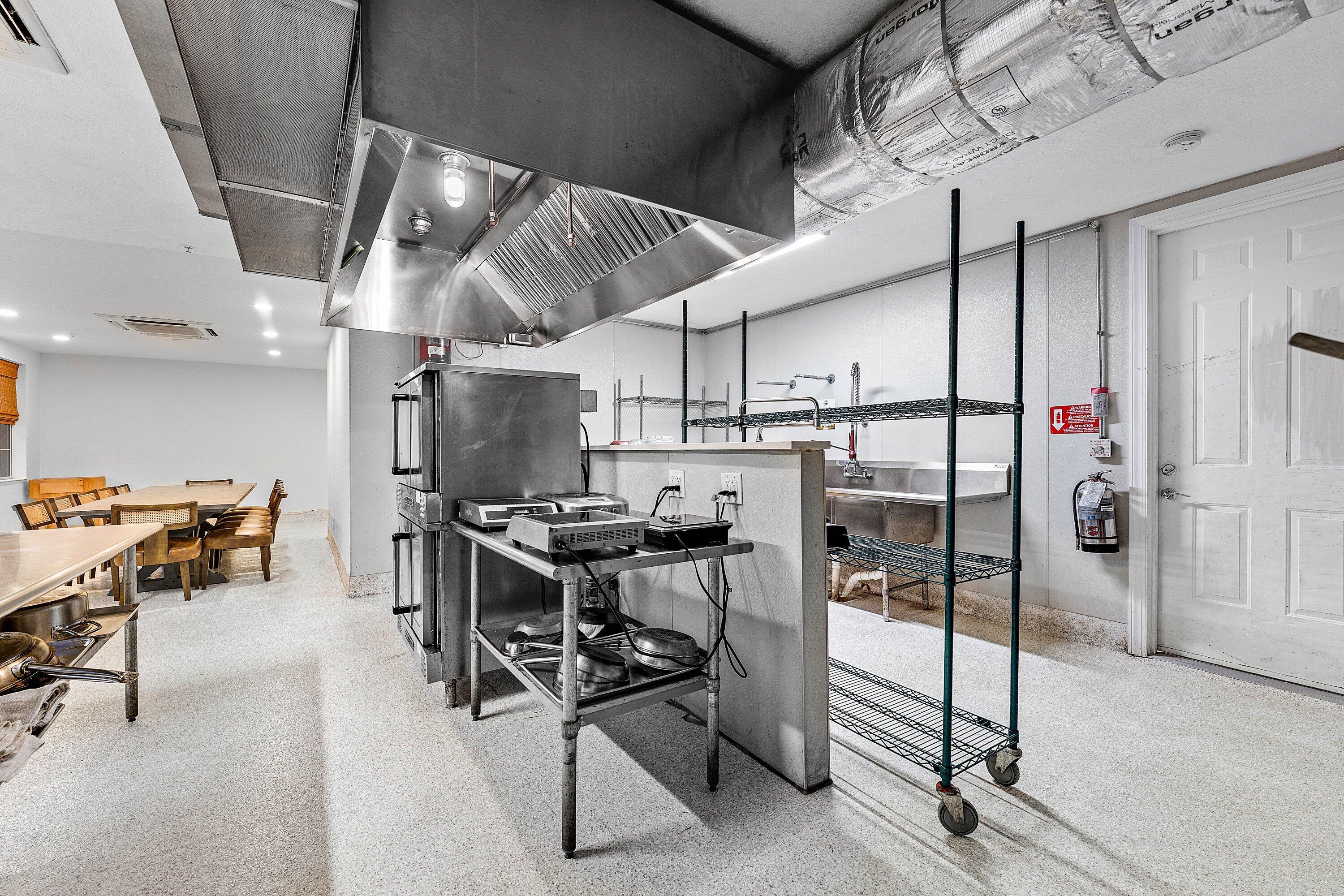 1056 Community Drive Jupiter, FL 33458 - Photo 40 of 50 a kitchen with stainless steel appliances kitchen island granite countertop a stove and a refrigerator