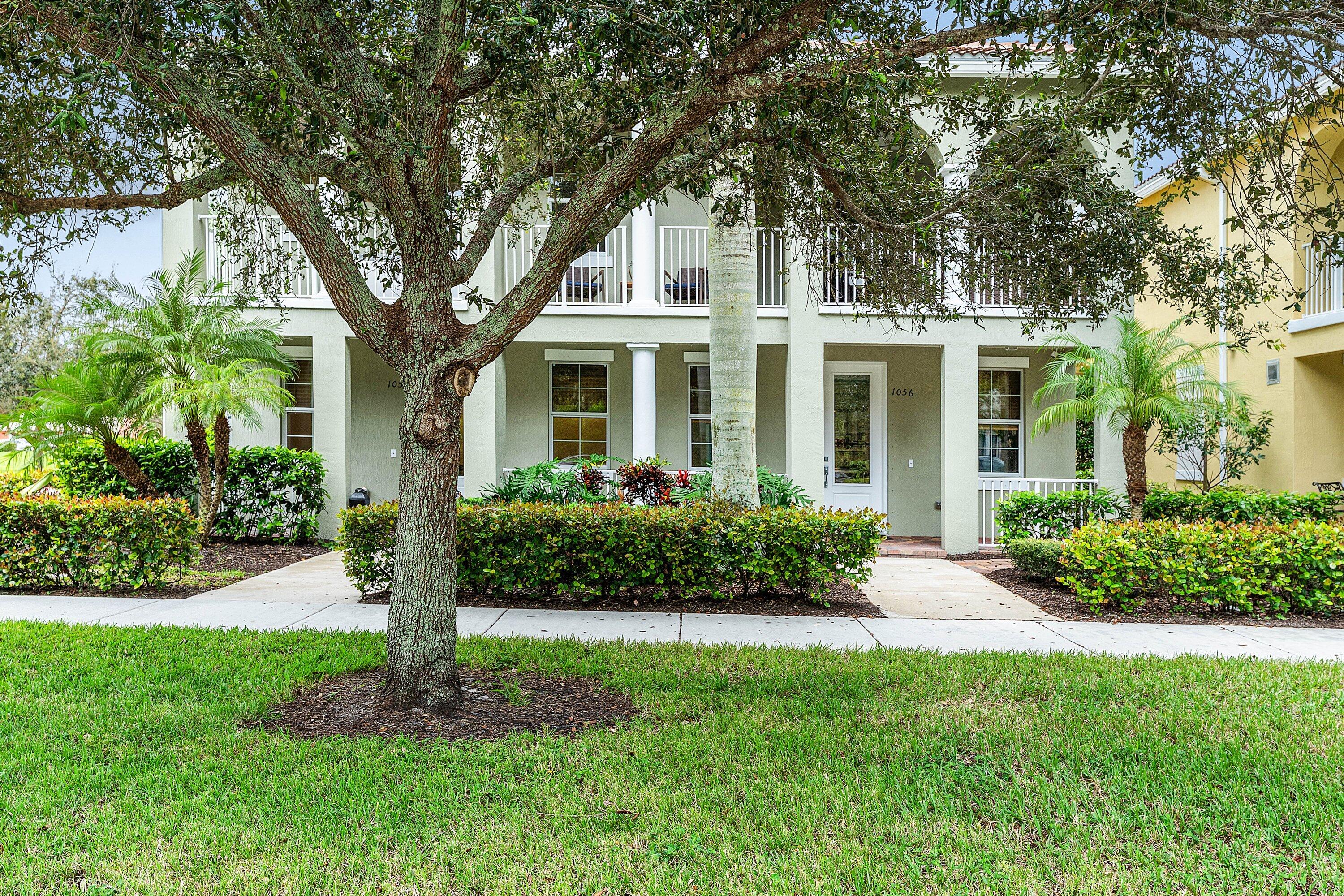 1056 Community Drive Jupiter, FL 33458 - Photo 43 of 50 a front view of a house with a garden and plants