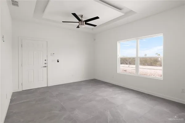 an empty room with a window and a fan