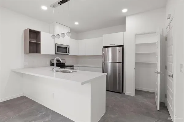 a kitchen with stainless steel appliances a refrigerator sink and microwave