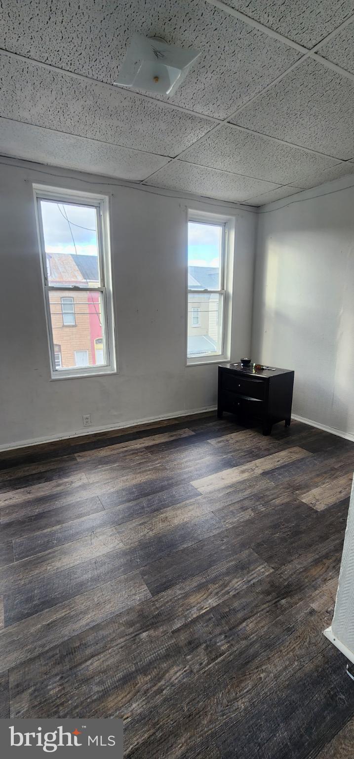 645 North 10th Street Reading, PA 19604 - Photo 17 of 27 an empty room with wooden floor and a window