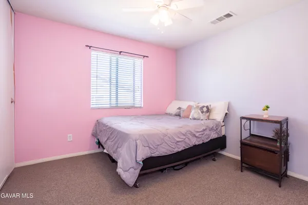 a bedroom with a bed and a ceiling fan
