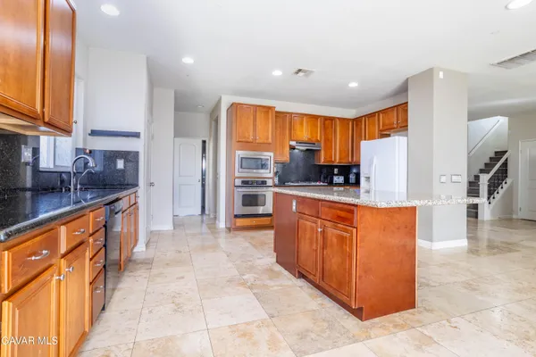 a large kitchen with stainless steel appliances kitchen island granite countertop a large counter top cabinets and stainless steel appliances