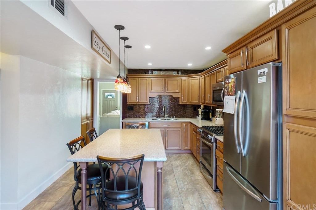 2419 Minuteman Way Costa Mesa, CA 92626 - Photo 14 of 26 a kitchen with stainless steel appliances a refrigerator a sink dishwasher a dining table and chairs with wooden floor