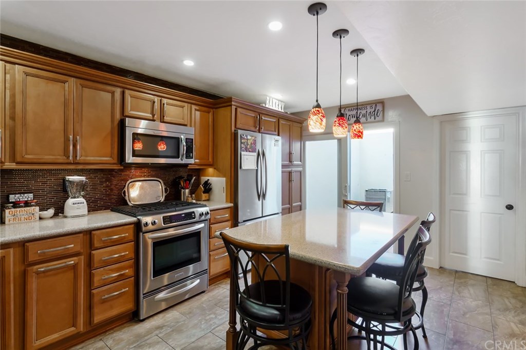 2419 Minuteman Way Costa Mesa, CA 92626 - Photo 2 of 26 a kitchen with stainless steel appliances granite countertop a stove top oven a refrigerator a sink and chairs