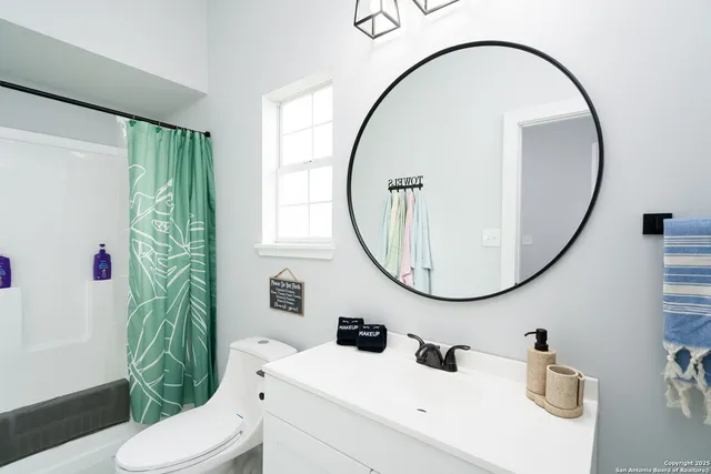 a bathroom with a sink a toilet and a mirror