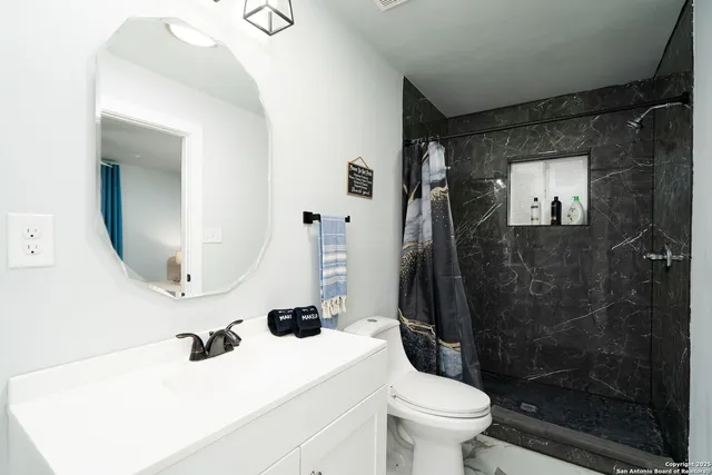 a bathroom with a sink toilet and shower