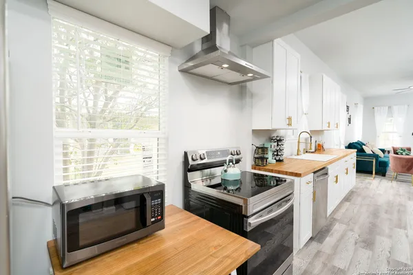 a kitchen with stainless steel appliances granite countertop a stove a sink and a microwave