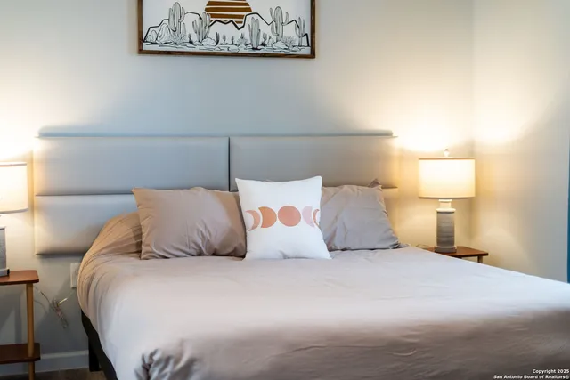 a large bed sitting in a bedroom with a lamp
