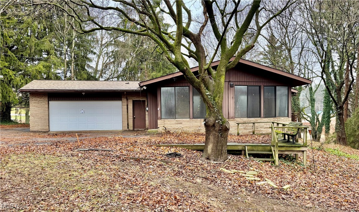 2898 Canton Road Uniontown, OH 44685 - Photo 2 of 20 View of front facade featuring a sunroom, brick siding, and a garage