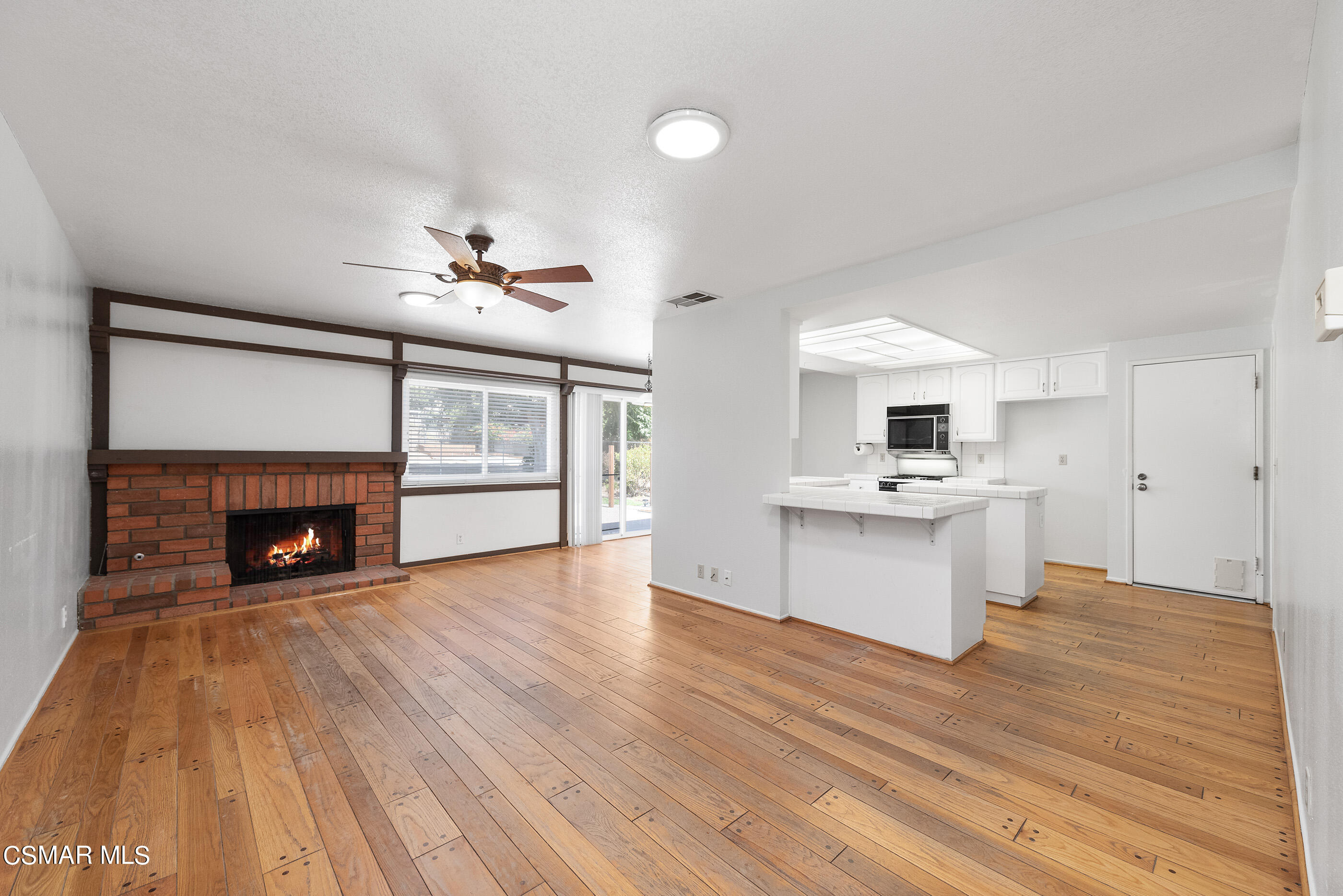 1217 Rambling Road Simi Valley, CA 93065 - Photo 6 of 64 a view of a kitchen with a sink a fireplace and wooden floor