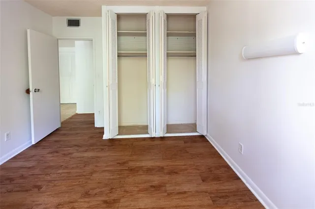 an empty room with wooden door and mirror