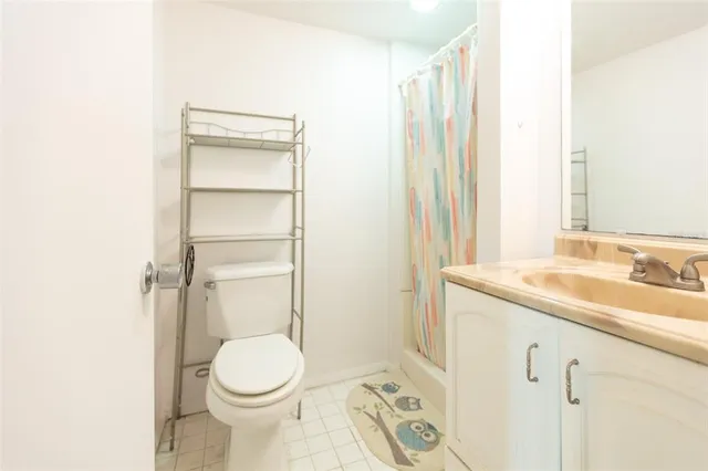a bathroom with a granite countertop toilet sink and mirror