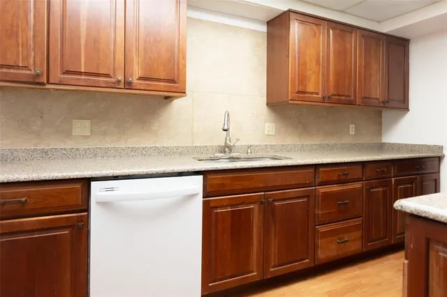 a kitchen with granite countertop wooden cabinets and a sink