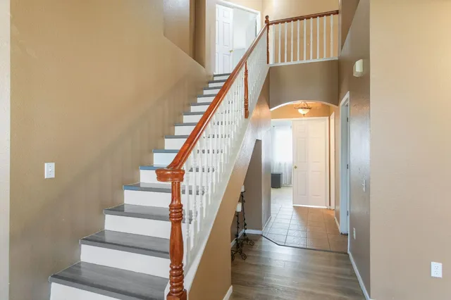 a view of staircase with wooden floor and white walls