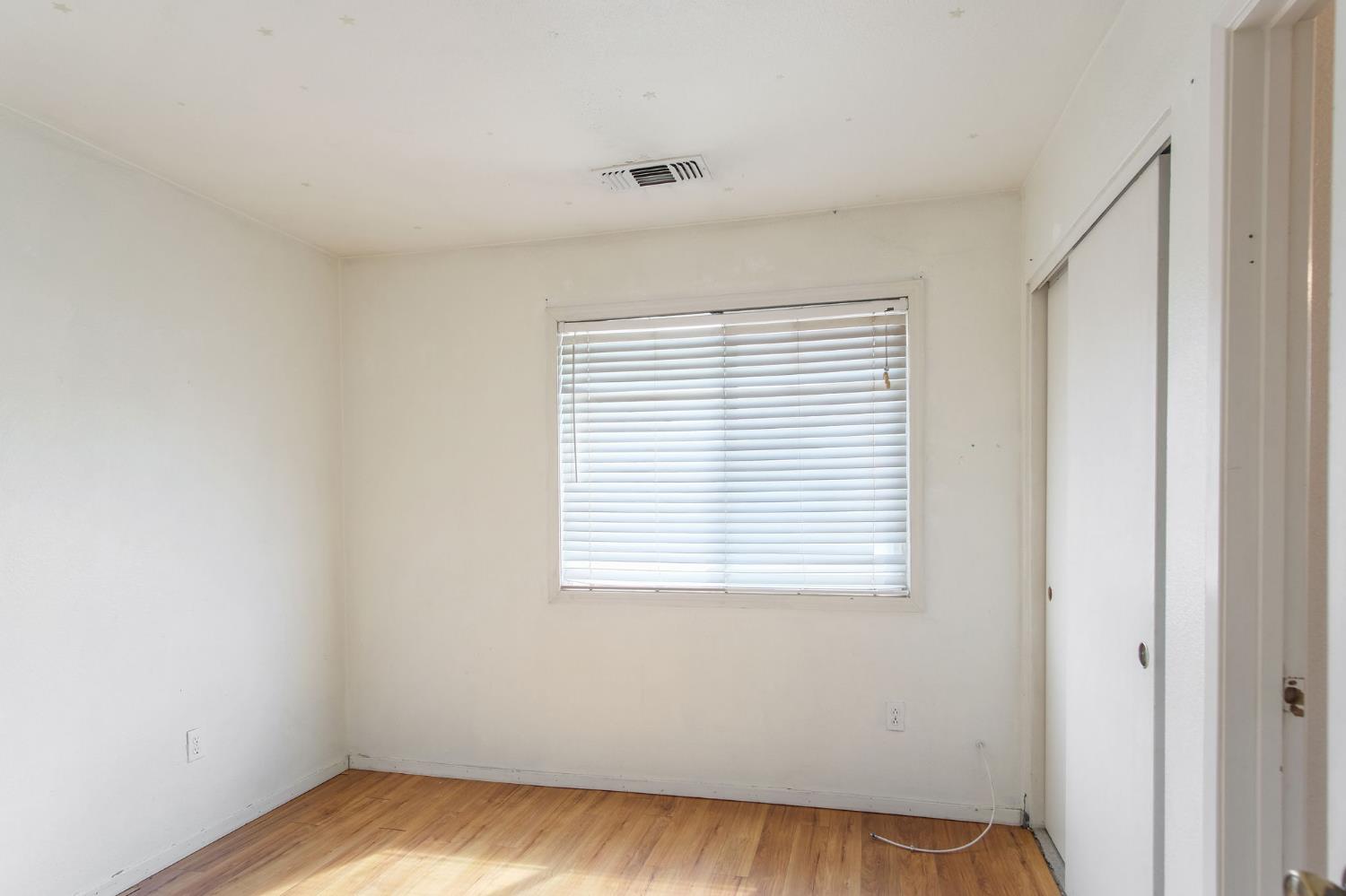 810 River Raft Court Modesto, CA 95351 - Photo 13 of 32 a view of an empty room with wooden floor and a window