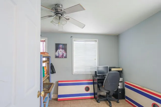 a view of a workspace with furniture and a window