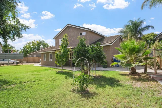 a backyard of a house with table and chairs