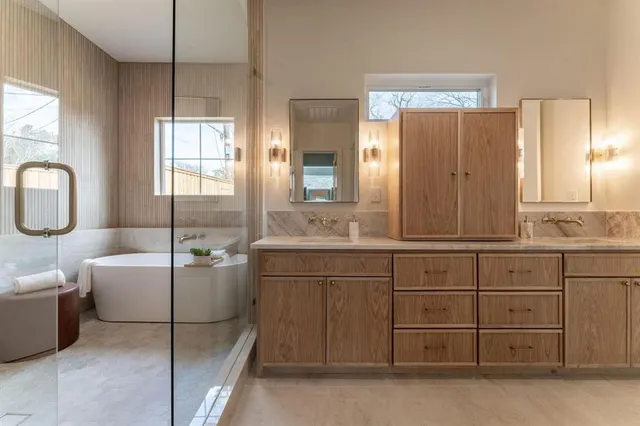 a bathroom with a granite countertop sink mirror and bathtub