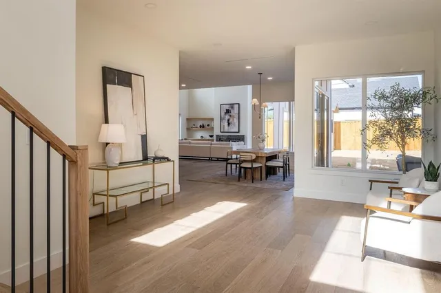 a living room with furniture and a table with wooden floor