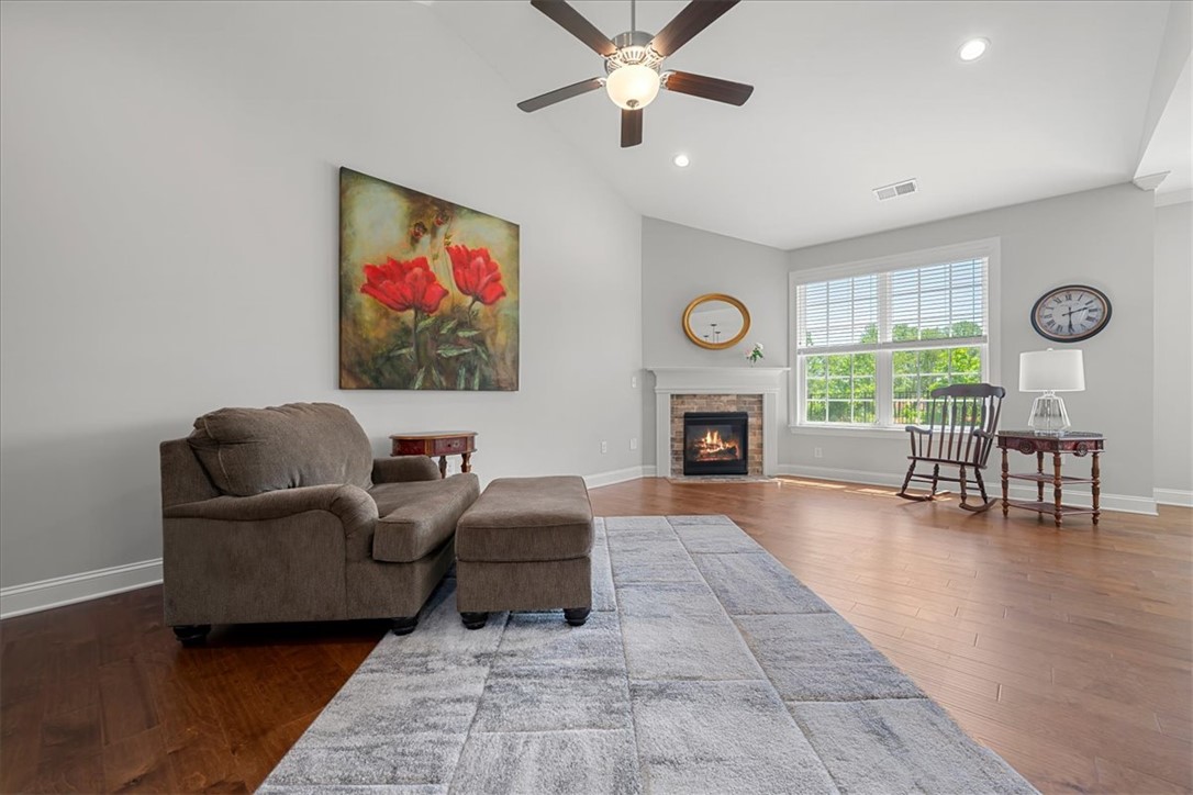 21 Barron Glenn Way Anderson, SC 29621 - Photo 9 of 48 This living area features rich hardwood flooring, a cozy fireplace, and abundant natural light from 2 large windows.