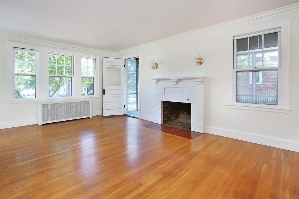 7 Lodge Road Newton, MA 02465 - Photo 3 of 11 an empty room with wooden floor fireplace and windows