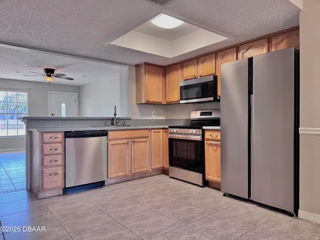a kitchen with stainless steel appliances granite countertop a stove a sink and a refrigerator