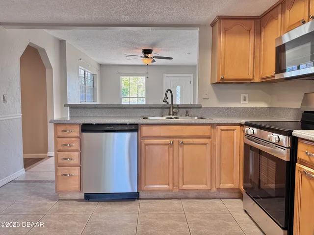 a kitchen with stainless steel appliances granite countertop a sink stove and cabinets