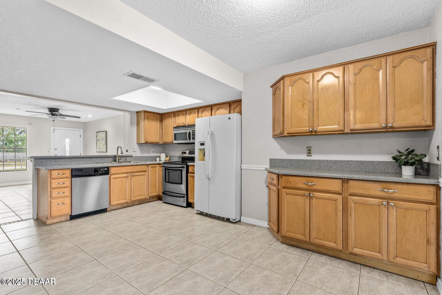 1702 Carolina Avenue Ormond Beach, FL 32174 - Photo 6 of 23 a kitchen with granite countertop a sink stainless steel appliances and cabinets