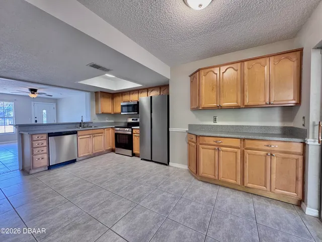 a kitchen with stainless steel appliances granite countertop a stove sink and cabinets