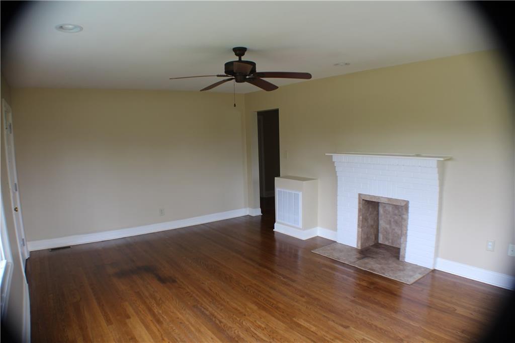 4123 Hickory Nut Ridge Road Hudson, NC 28638 - Photo 16 of 27 a view of a room with wooden floor and a ceiling fan