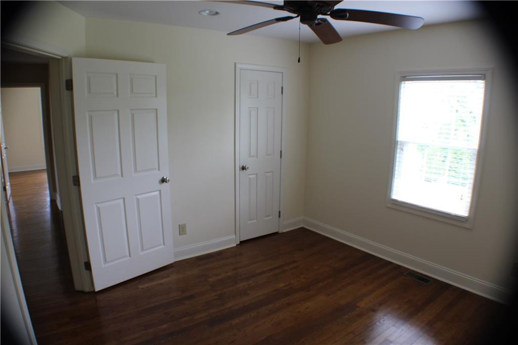 4123 Hickory Nut Ridge Road Hudson, NC 28638 - Photo 8 of 27 an empty room with wooden floor cabinet and windows