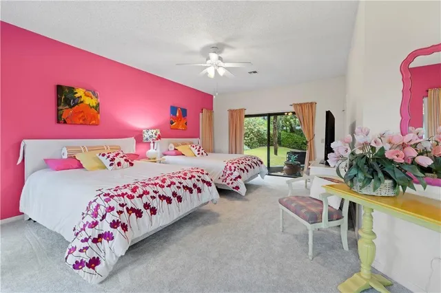 a bedroom with a bed potted plant on the dresser and a large window