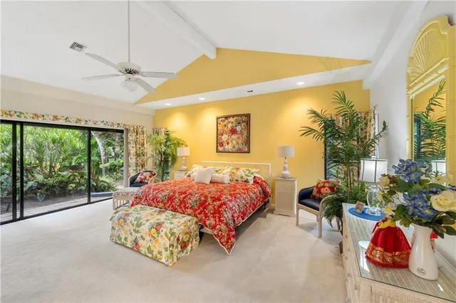a spacious bedroom with large bed and a chandelier