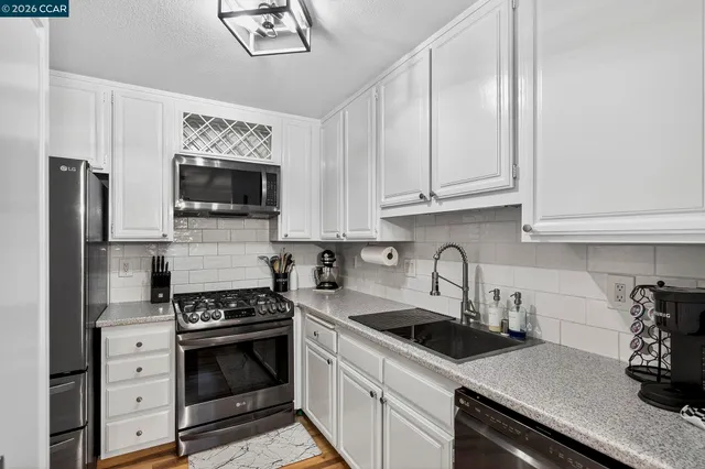 a kitchen with granite countertop a refrigerator stove and sink