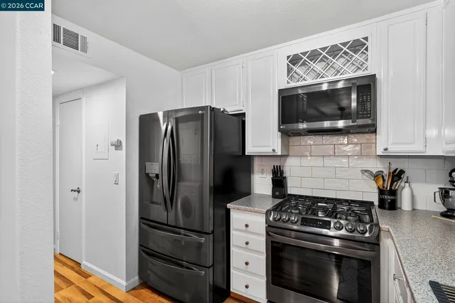 a kitchen with stainless steel appliances sink refrigerator and cabinets