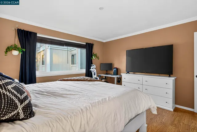 a bedroom with a bed and a a flat screen tv