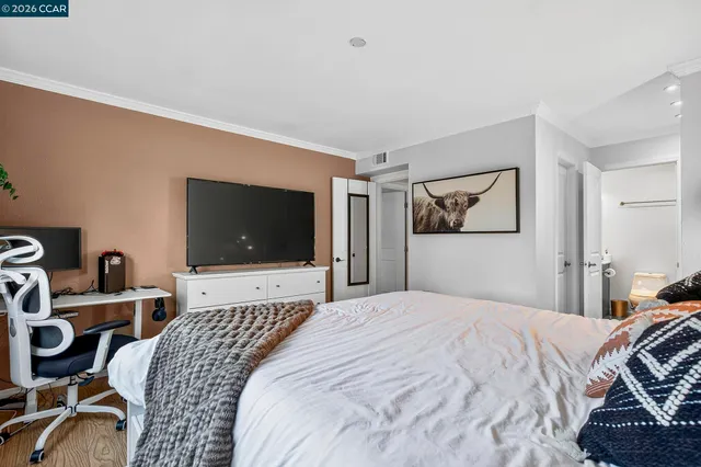 a bed room with a bed and a painting on the wall