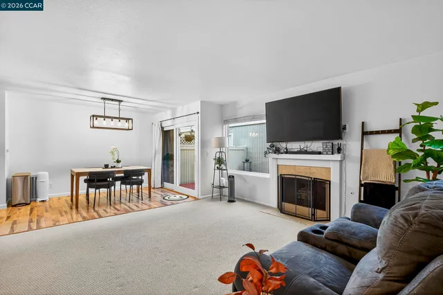a living room with furniture a fireplace and a flat screen tv