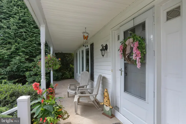 a kitchen with stainless steel appliances granite countertop a dining table chairs refrigerator and wooden floor