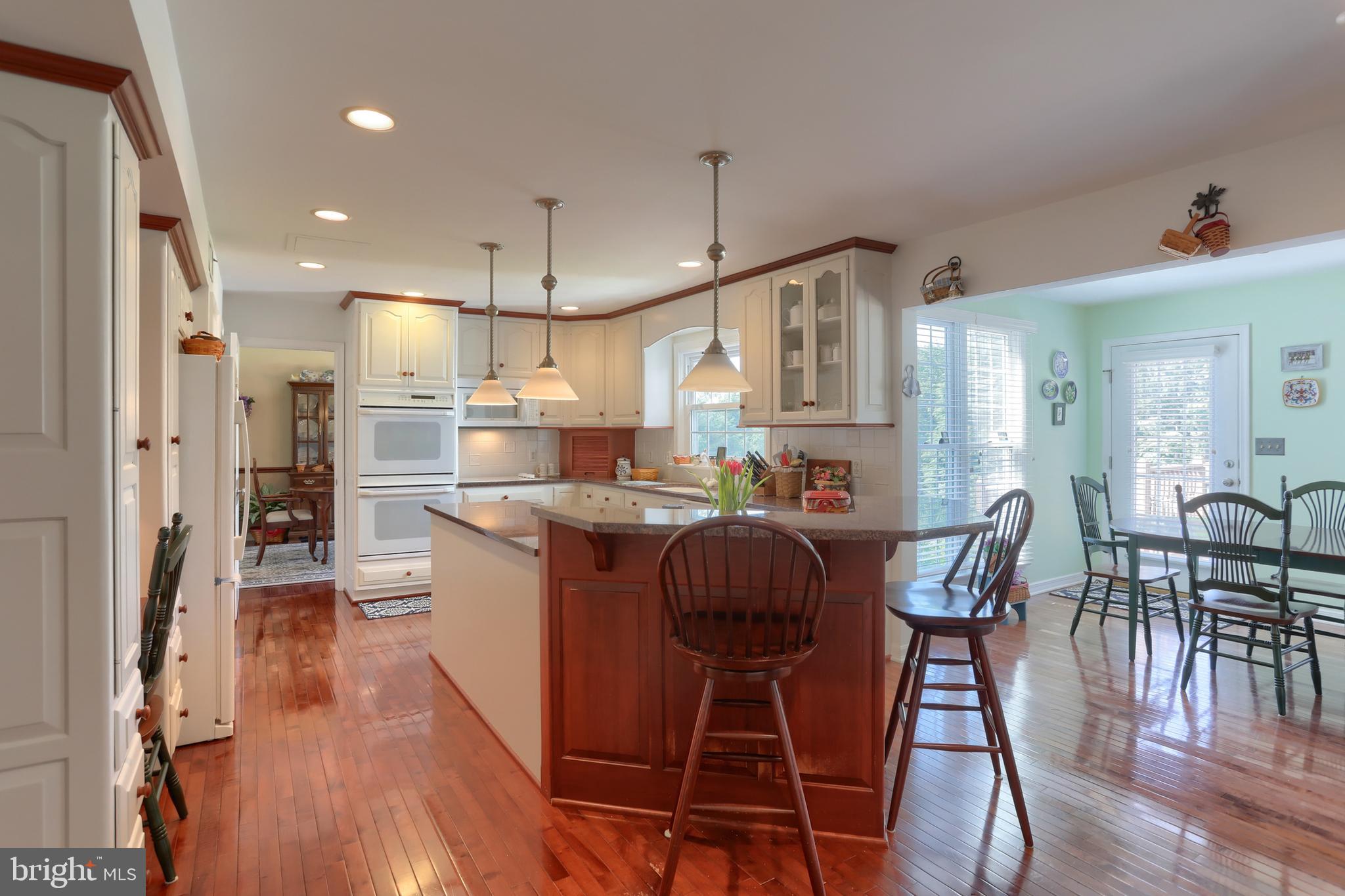 3 Banbury Road Hummelstown, PA 17036 - Photo 19 of 85 a kitchen with stainless steel appliances granite countertop a dining table chairs refrigerator and wooden floor
