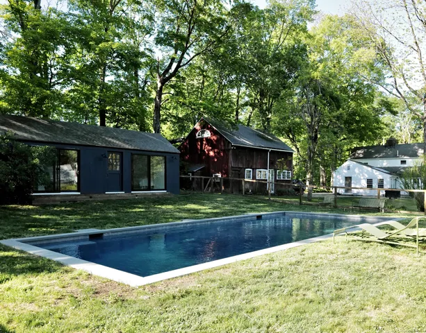 a view of a house with a yard and a large tree