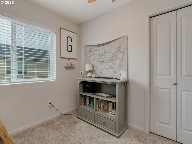 a view of an empty room with cabinet and a window