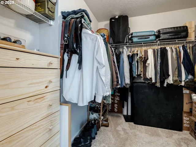 a view of walk in closet with clothes and shoes