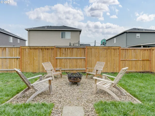 a backyard of a house with table and chairs
