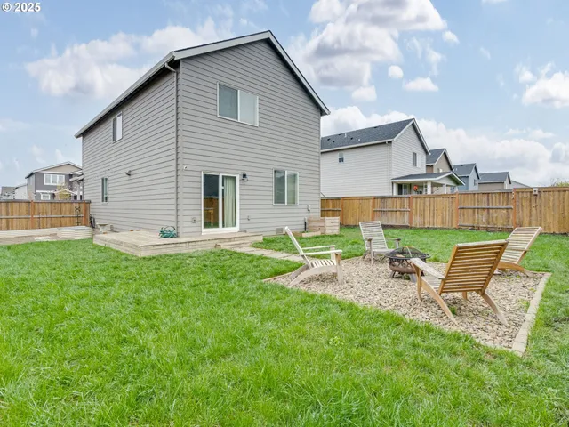a view of a house with backyard and sitting area