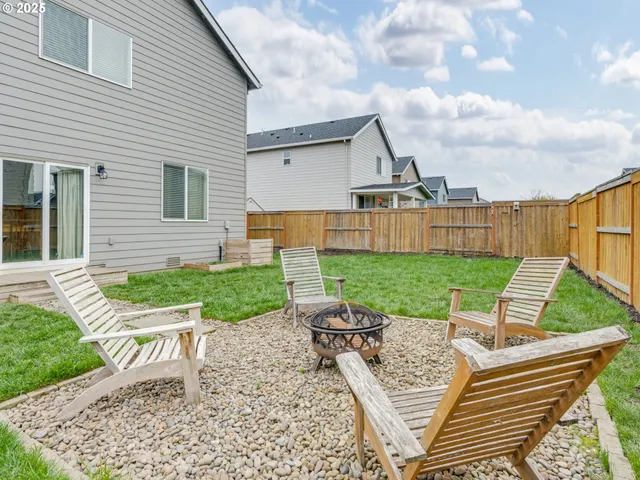 a view of a patio with table and chairs with wooden fence and plants
